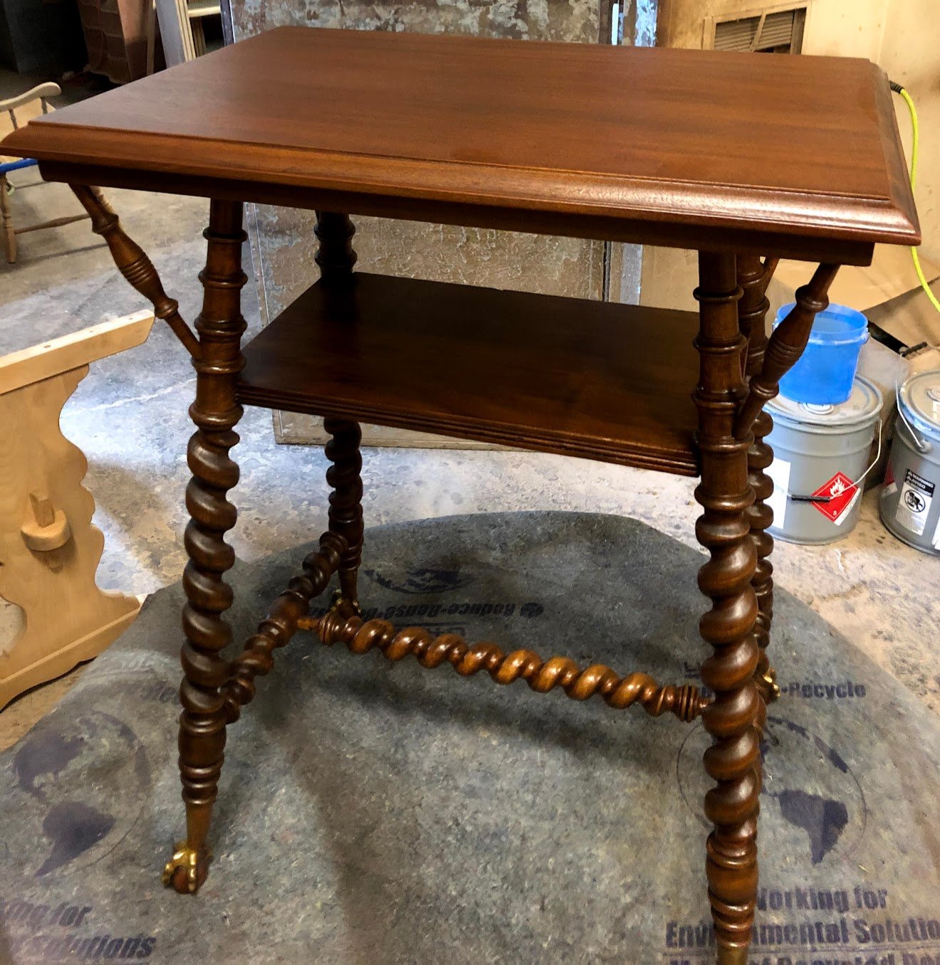 1880s Victorian parlor table with hand-turned barley-twist legs, brass ball-and-claw feet, and a lower display shelf — fully refinished by Doll Furniture Company