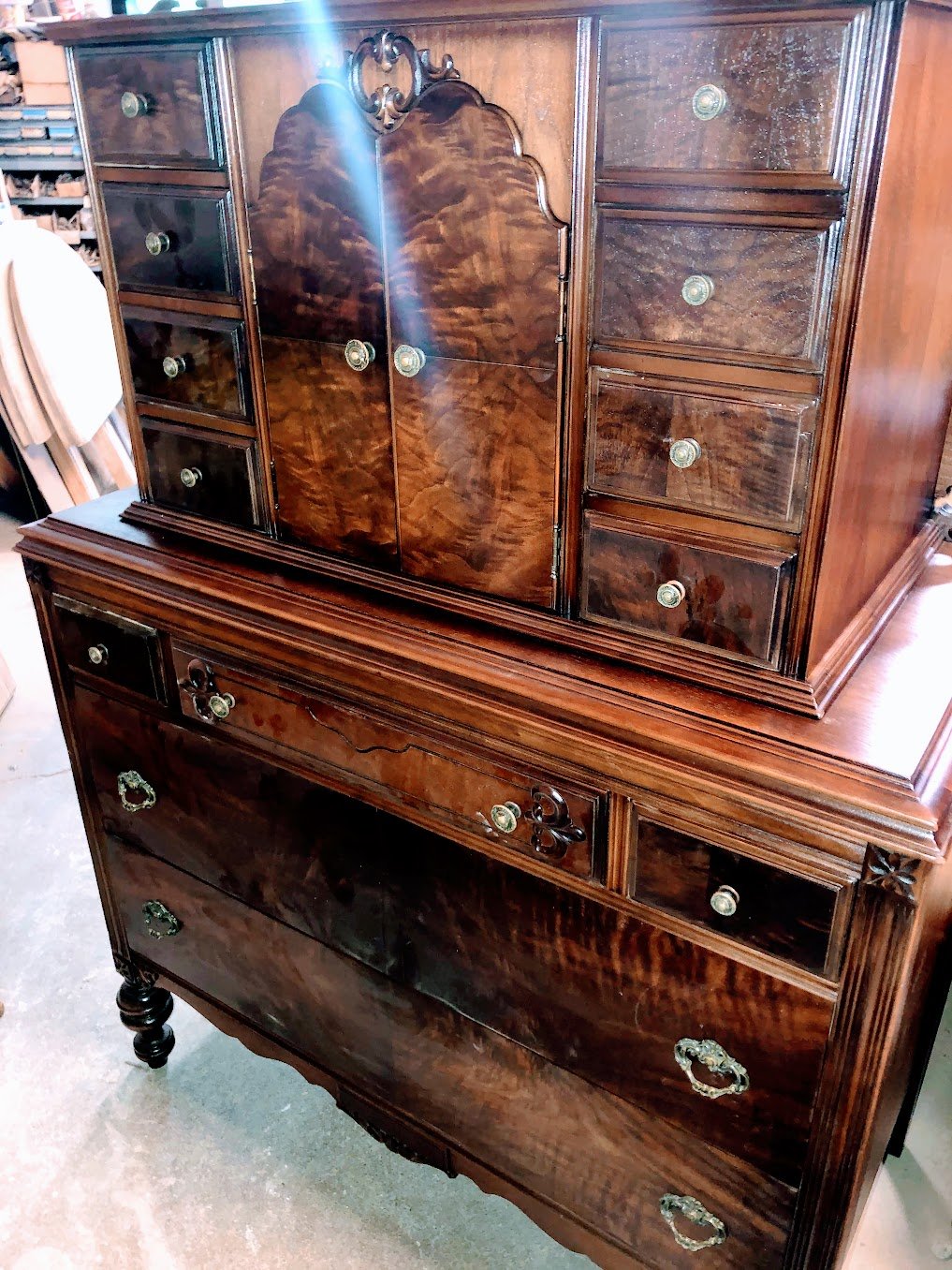 Antique burl walnut chest-on-chest highboy with stunning bookmatched veneer panels, fluted columns, and original glass drawer pulls — refinished by Doll Furniture Company