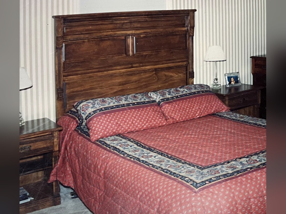 The same custom bedroom set installed and finished in the customer's home, stained a rich walnut, with nightstands flanking the bed