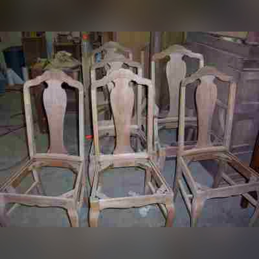 Queen Anne style chair frames freshly stripped down to bare wood in the Strip-o-lator at Doll Furniture Company — ready for sanding, staining, and finishing