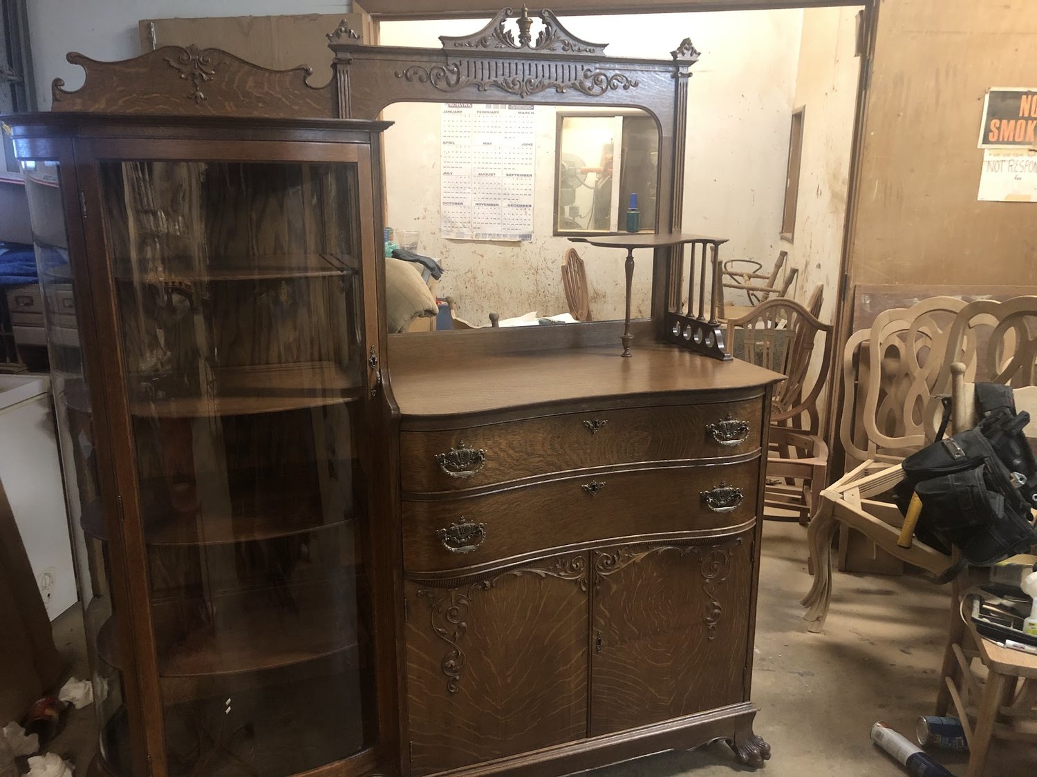 Antique Victorian quarter-sawn oak side-by-side secretary with curved glass china cabinet, beveled mirror, and hand-carved crest — refinished by Doll Furniture Company